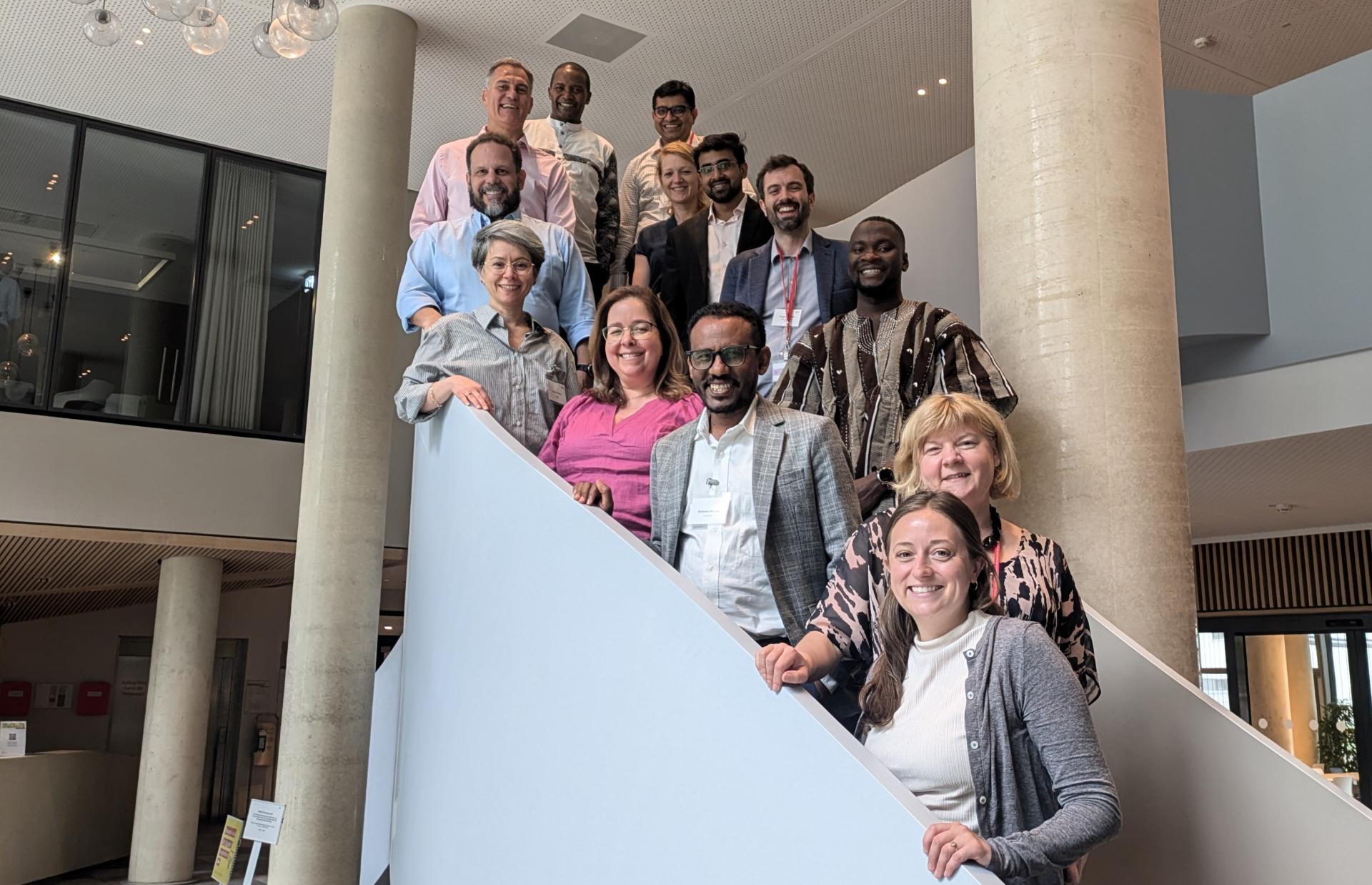 A group of smiling adults standing on a staircase
